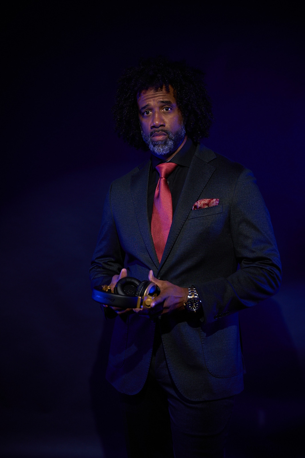 DJ H.A.L.O. — Javier Echols in navy suit holding headphones